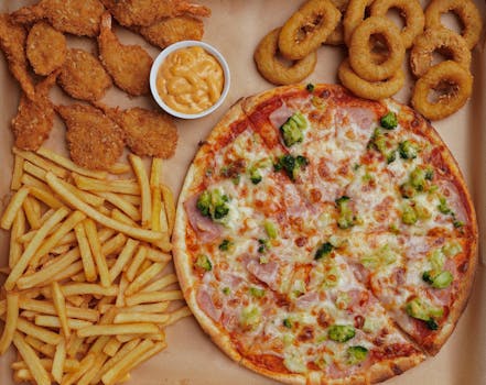 pexels-photo-32116402-32116402 A visually appetizing array of pizza, fries, onion rings, shrimp and cheese dip.