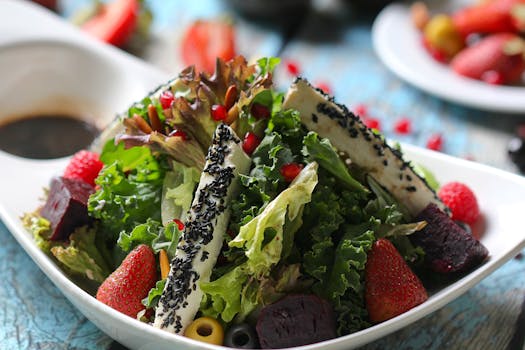 pexels-photo-5639341-5639341 A colorful mixed green salad with strawberries and sesame cheese, perfect for a healthy diet.